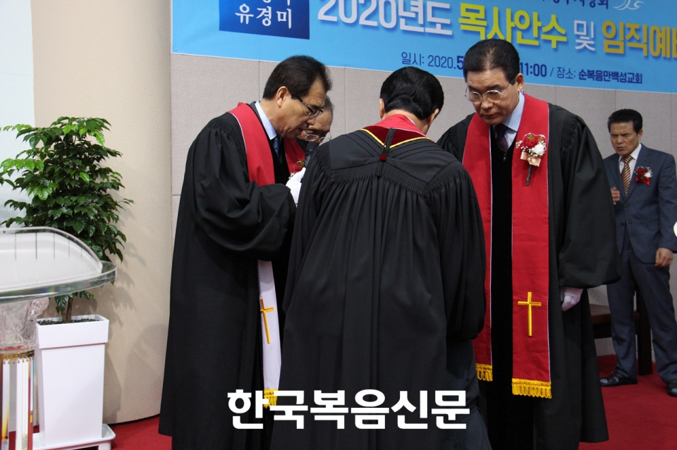 안수위원들이 김성자 유경미 목사에게 안수하고 있다.